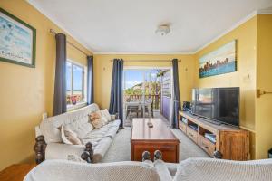 a living room with a couch and a tv at The Castle in Baylys Beach