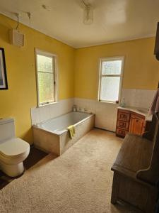 a bathroom with a tub and a toilet and a sink at The Castle in Baylys Beach +30 photos