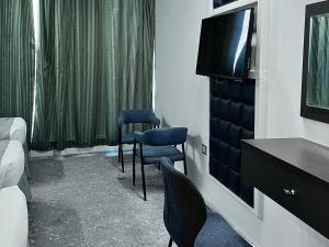 a hotel room with two chairs and a television at Montana Golden Hotel in Mecca
