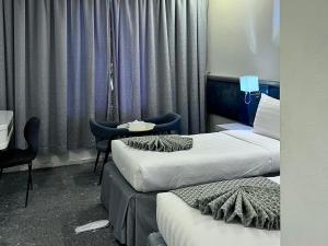 a hotel room with two beds and a table and chairs at Montana Golden Hotel in Mecca