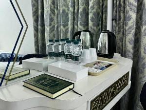 a table with bottles of water and books on it at Montana Golden Hotel in Mecca