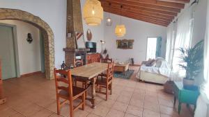 a living room with a wooden table and chairs at Casa Verde Oliva in Sedella