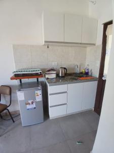 a small kitchen with a sink and a refrigerator at Apart La Jose in Río Cuarto +3 photos