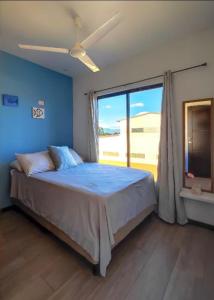 a bedroom with a large bed with a large window at Casa Solana in Puntarenas +16 photos
