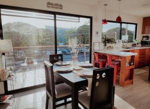 a kitchen with a table and chairs and a large window at Casa Solana in Puntarenas