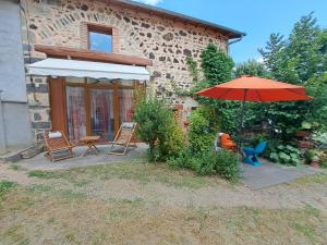 a patio with a table and an umbrella and chairs at Le Céleste - Maison de vacances familiale in Châtel-Guyon