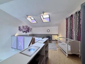 a small room with a crib and a room with a room at Le Céleste - Maison de vacances familiale in Châtel-Guyon +13 photos