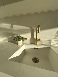 a white kitchen with a sink with a faucet at Brúarárbyggð B1 in Blaskogabyggo +29 photos