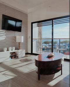 a living room with a table and a large window at Casa Solana in Puntarenas