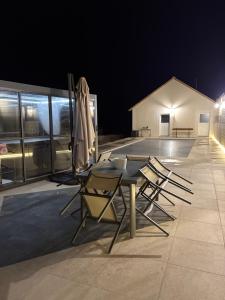 a table and chairs on a patio at night at Entre Loire et Zoo Chambres d hôtes in Meusnes