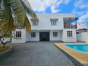 a white house with a swimming pool in front of it at TecTec 2 Appartment 1 in Pereybere