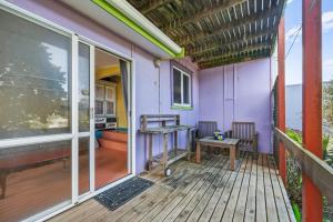a porch with a purple house with a table and a bench at The Castle in Baylys Beach