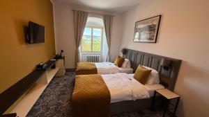 ein Hotelzimmer mit zwei Betten und einem Fenster in der Unterkunft Hotel Tynec in Týnec nad Sázavou