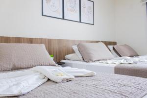 two beds sitting next to each other with towels on them at Hotel Cheffer in Pôrto Ferreira