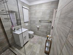 a bathroom with a shower and a toilet and a sink at A Pearl Place in Pretoria +19 photos