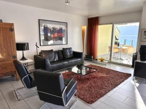 a living room with a black couch and a table at Residenza Acapulco I by Fewotessin in Moscia