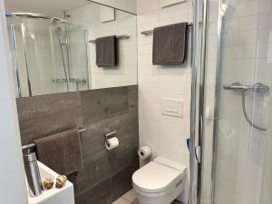 a bathroom with a toilet and a glass shower at Residenza Acapulco I by Fewotessin in Moscia +29 photos
