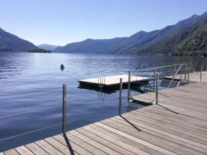 a dock on a lake with a person in the water at Residenza Acapulco I by Fewotessin in Moscia