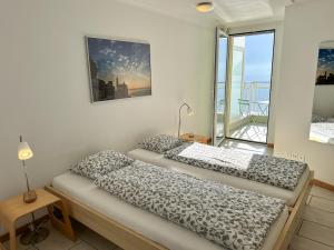 two beds in a room with a balcony at Residenza Acapulco II by Fewotessin in Moscia