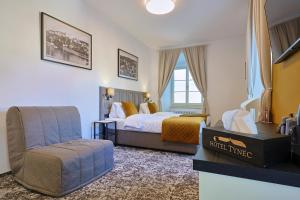 ein Hotelzimmer mit einem Bett und einem Stuhl in der Unterkunft Hotel Tynec in Týnec nad Sázavou + 57 Fotos