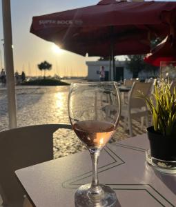 a glass of wine sitting on top of a table at Townhouse with Rooftop Terrace in Olhão in Olhão +25 photos