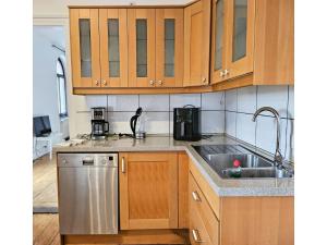 a kitchen with wooden cabinets and a stainless steel sink at Apartment für Monteure oder Reisende in Bad Camberg
