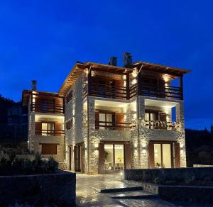 a large building with lights on it at night at Levanta Guesthouse in Synikia Mesi Trikalon