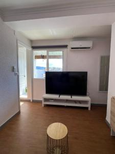 a living room with a flat screen tv and a table at El Rincón Azul in Jalance