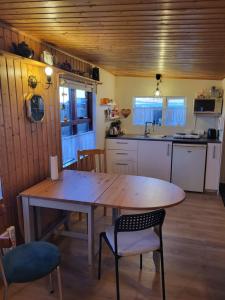 a kitchen with a wooden table and a table and chairs at Vonarland hús með einu svefnherbergi in Stokkseyri