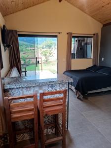 a bedroom with a bed and a table and chairs at Refúgio São Tomé in São Thomé das Letras