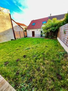 a yard with a house and a grassy yard at Maison Cozy Deco P0P' proche Paris in Villejust