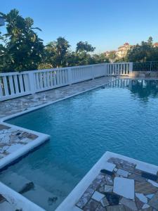 a swimming pool with a white fence around it at Peaceful Private Home With Exclusive Swimming Pool in Montego Bay