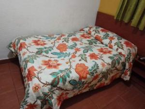 a bed in a room with a floral bedspread at Hotel el Dorado La Candelaria in Bogotá