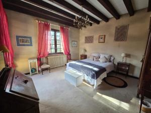 a bedroom with a large bed and red curtains at Les Pierres Du Périgord 200 in Couze-et-Saint-Front