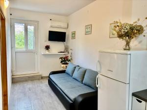 a living room with a couch and a refrigerator at Apartments Mare in Mlini