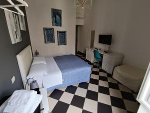a bedroom with a bed and a checkered floor at Manì Rooms Marina in Cagliari