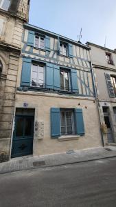 a building with blue doors and windows on a street at L'écrin de Nature T2 Centre Historique in Auxerre