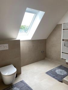 ein Badezimmer im Dachgeschoss mit Toilette und Dachfenster in der Unterkunft Elb Front in Winsen + 29 Fotos