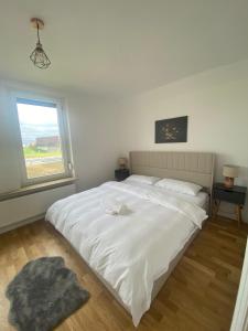 ein Schlafzimmer mit einem großen weißen Bett und einem Fenster in der Unterkunft Elb Front in Winsen