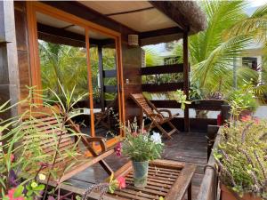 a porch with chairs and potted plants on it at Residence Coco Plage in Elinkinde