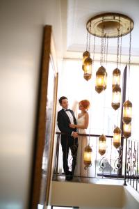 a bride and groom standing on a staircase in front of a mirror at Saint John Hotel in Selcuk