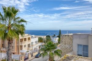 a view of a city with palm trees and the ocean at Luxurious Villa with pool in Il-Mielaħ
