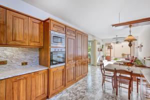a kitchen with wooden cabinets and a table with chairs at Luxurious Villa with pool in Il-Mielaħ