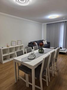 a white table and chairs in a living room at Pátio do Garajau Apartamento T2 com estacionamento e varanda perto do Cristo Rei in Caniço