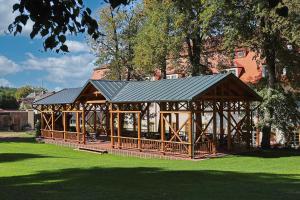 ein hölzerner Pavillon mit schwarzem Dach in einem Park in der Unterkunft Hotel Tynec in Týnec nad Sázavou