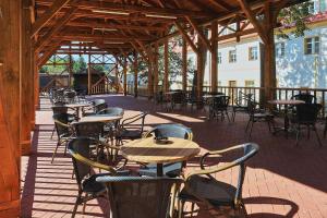 eine leere Terrasse mit Tischen und Stühlen in einem Gebäude in der Unterkunft Hotel Tynec in Týnec nad Sázavou