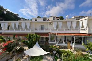 a large white building with a garden in front of it at Gioula's Residence in Patitiri