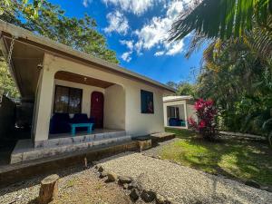 a house with a blue bench on the porch at Koba Apartments Santa Teresa in Santa Teresa Beach