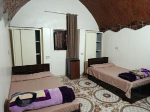 a room with two beds in a room at Rooma ka Guest House in Aswan