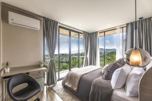 a bedroom with a bed and a desk and a window at Villa 360 in Calaca +47 photos